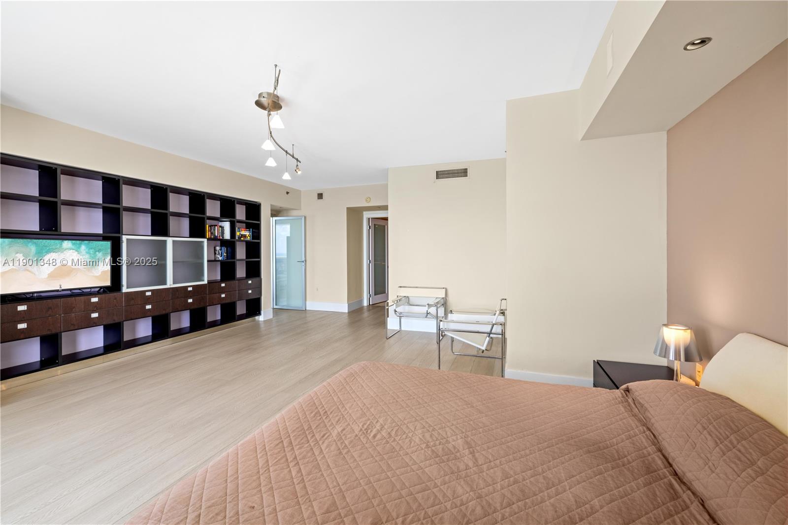 400 Alton Road, Unit 3006 Miami Beach, FL 33139 - Photo 14 of 28 a bedroom with a bed and a chandelier