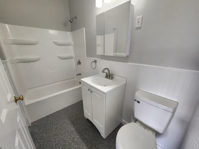 a white toilet sitting next to a bath tub