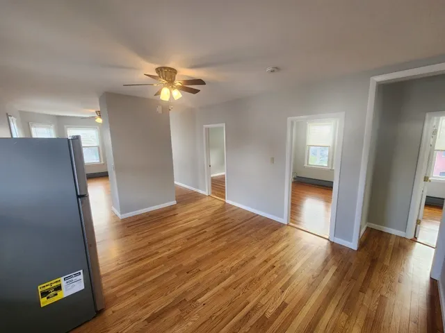 a view of empty room with wooden floor