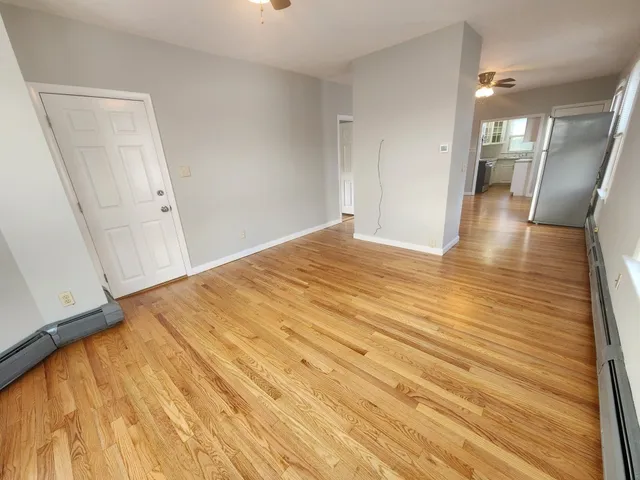 a view of a room with wooden floor and white walls
