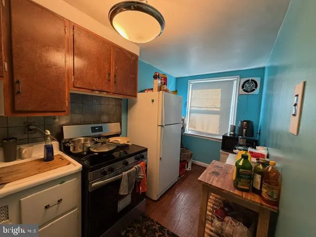 a kitchen with stainless steel appliances granite countertop a stove refrigerator and a sink