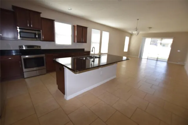 a kitchen with stainless steel appliances granite countertop a sink and a stove top oven