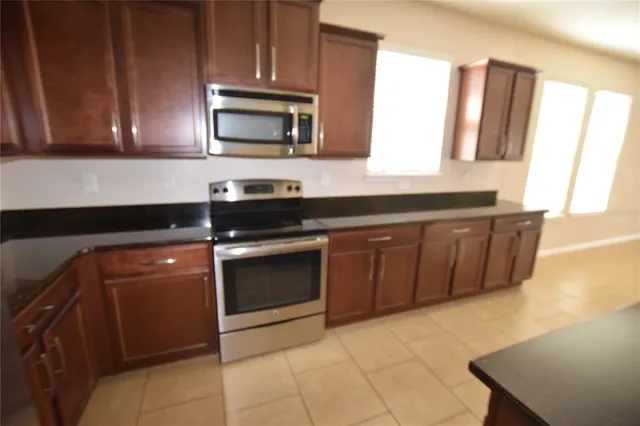 a kitchen with granite countertop a stove and a microwave