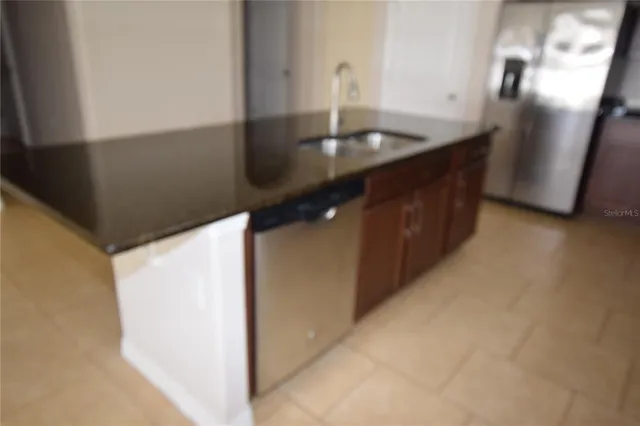 a kitchen with stainless steel appliances a sink and a refrigerator