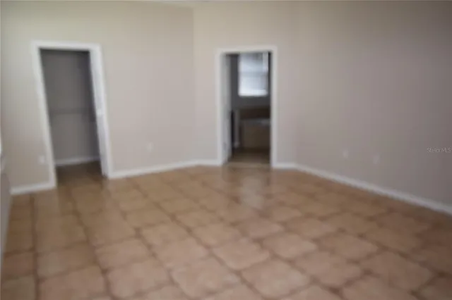 an empty room with closet and entrance to other room