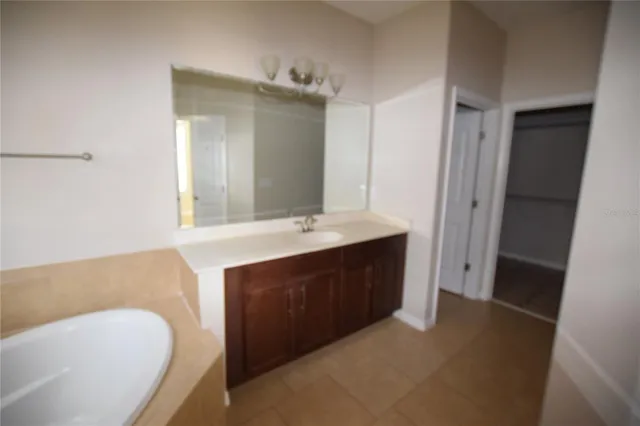 a bathroom with a tub sink and mirror