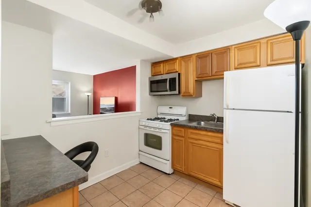 a living room with furniture and a flat screen tv with kitchen view