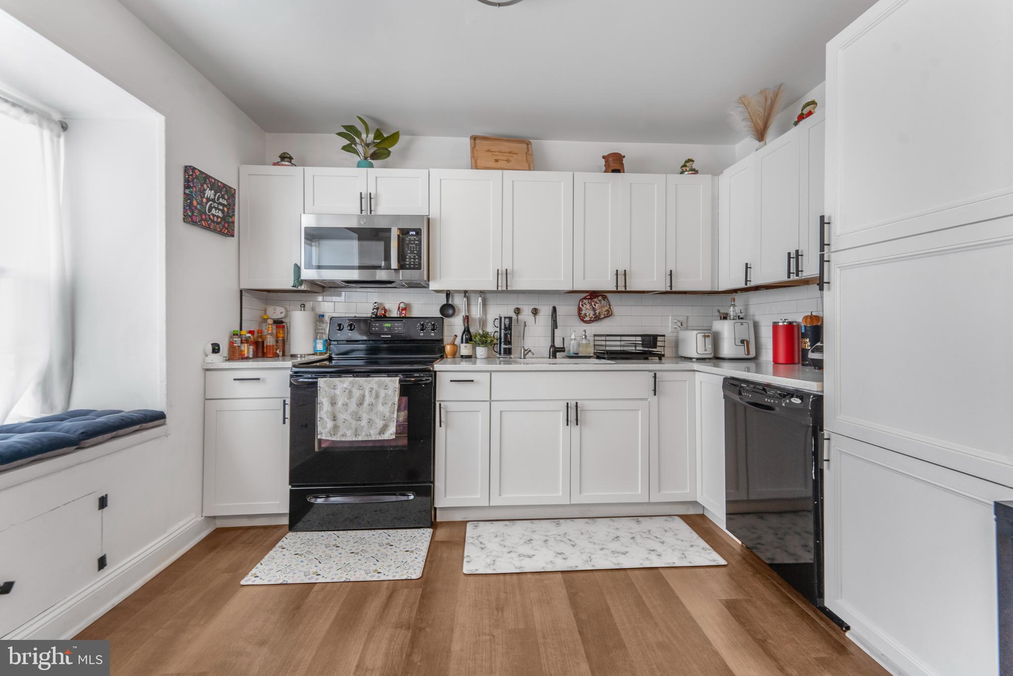 15307 Arbory Way, Unit 6 Laurel, MD 20707 - Photo 5 of 23 a kitchen with white cabinets and appliances
