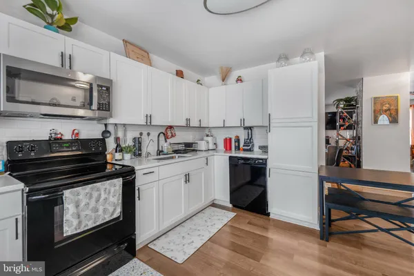 a kitchen with granite countertop a stove top oven cabinets and a refrigerator