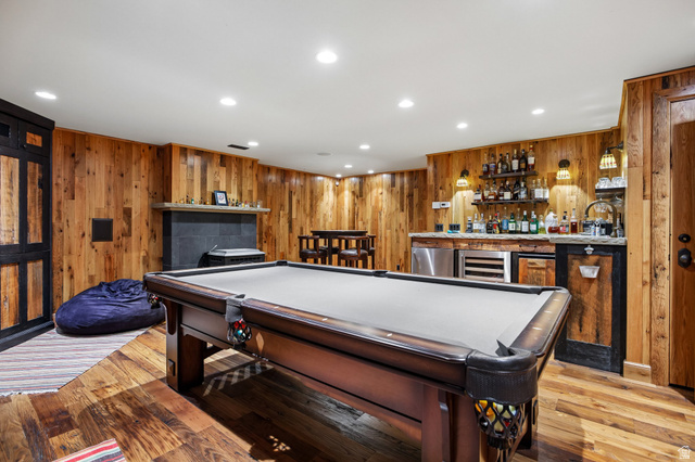 10205 East Moose Loop Road Salt Lake City, UT 84121 - Photo 28 of 50 Recreation room featuring wood-finish flooring, wood plank wall paneling, recessed lighting, and a built-in wet bar with a wine cooler