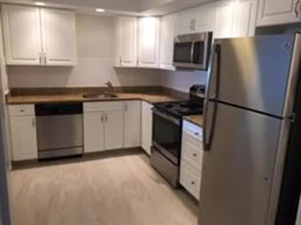 a kitchen with granite countertop a refrigerator stove and microwave