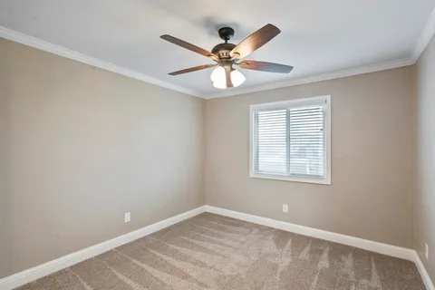 an empty room with a window and a fan