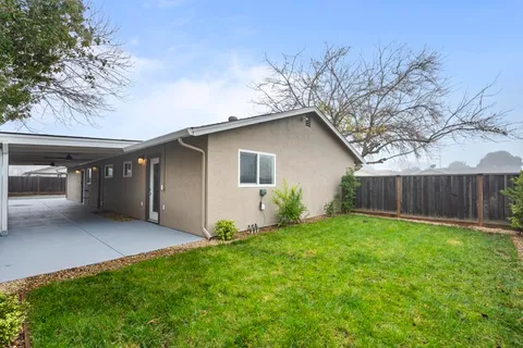 a view of an house with backyard space and wooden fence