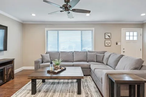 a living room with furniture and a wooden floor