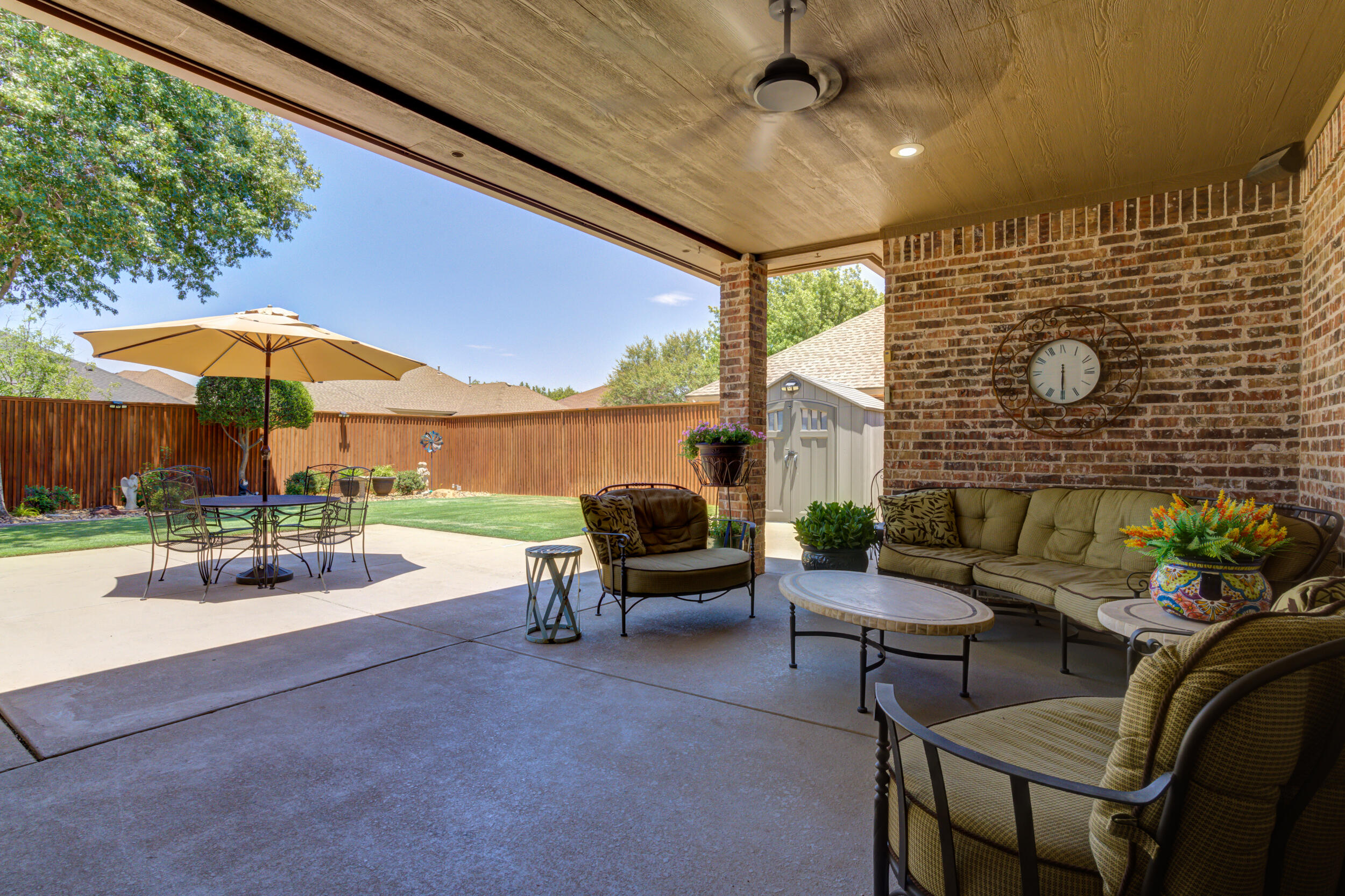 6008 89th Street Lubbock, TX 79424 - Photo 50 of 61 a patio with a table and chairs under an umbrella