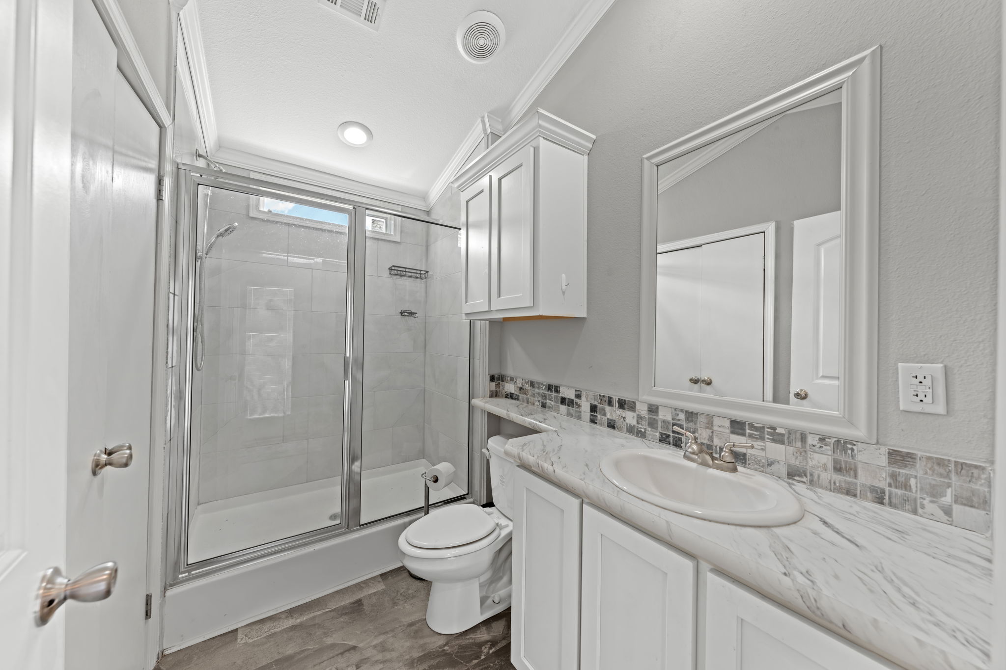 212 Meuth Cemetery Road Red Rock, TX 78662 - Photo 29 of 38 Bathroom with a shower stall, vanity, crown molding, dark wood-style flooring, and backsplash