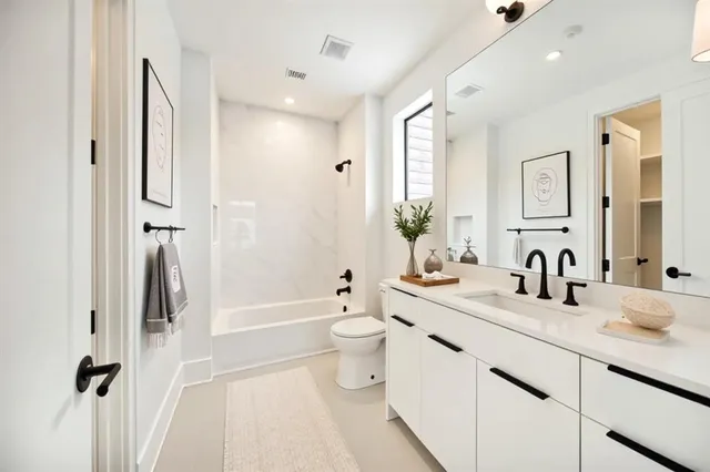 a bathroom with a double vanity sink toilet mirror and shower