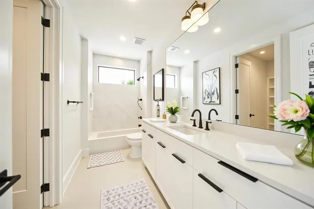 a bathroom with a granite countertop sink mirror and a bath tub