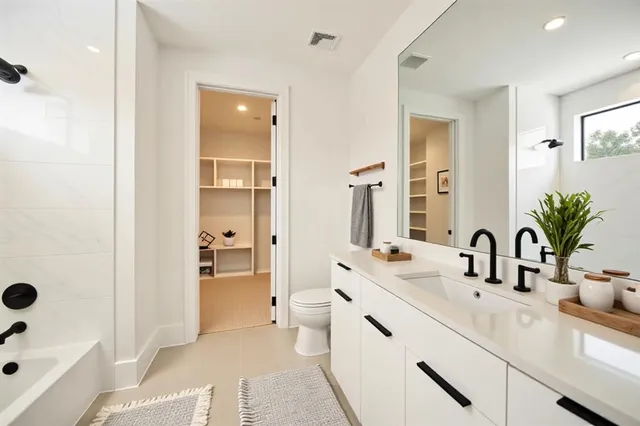 a bathroom with a double vanity sink a mirror and a bathtub