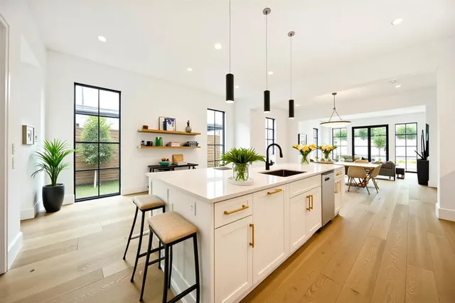 a kitchen with white cabinets and sink