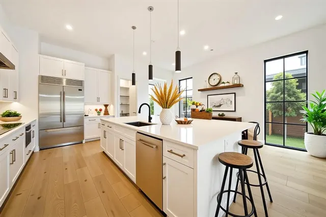 a kitchen with sink a refrigerator and wooden floor
