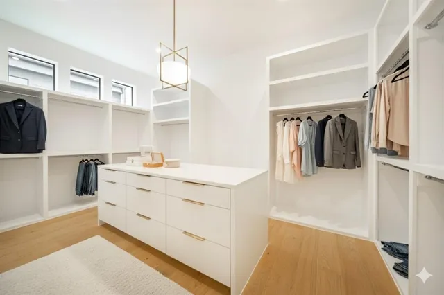 a view of walk in closet with clothes and shoes