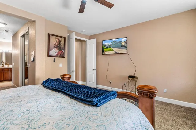 a bedroom with a bed and painting on the wall