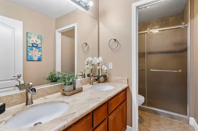 a bathroom with a granite countertop sink a large mirror and a shower