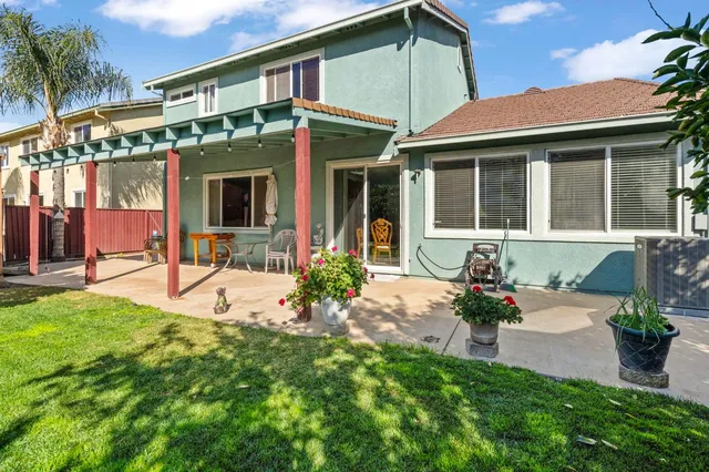 a front view of a house with a yard and potted plants