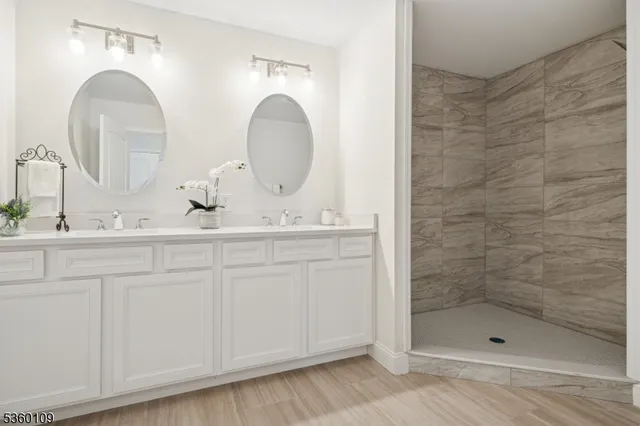 a bathroom with a double vanity sink mirror and shower