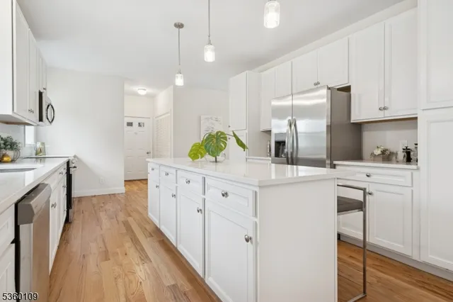 a kitchen with cabinets stainless steel appliances and wooden floor
