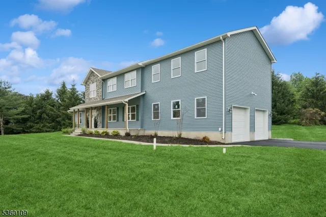 a view of a yard in front of a house with large windows