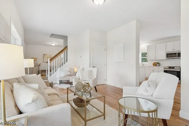 a living room with furniture a dining table and a refrigerator