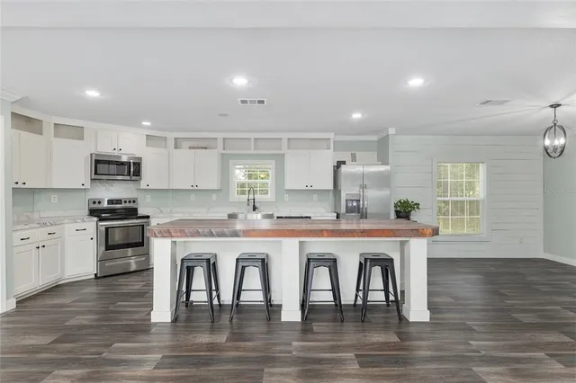a large white kitchen with a table and chairs in it