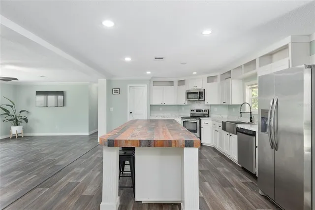 a kitchen with kitchen island a counter top space cabinets and stainless steel appliances