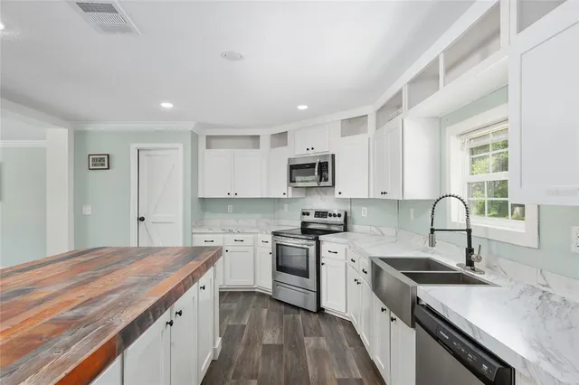a kitchen with stainless steel appliances granite countertop a sink dishwasher stove and refrigerator