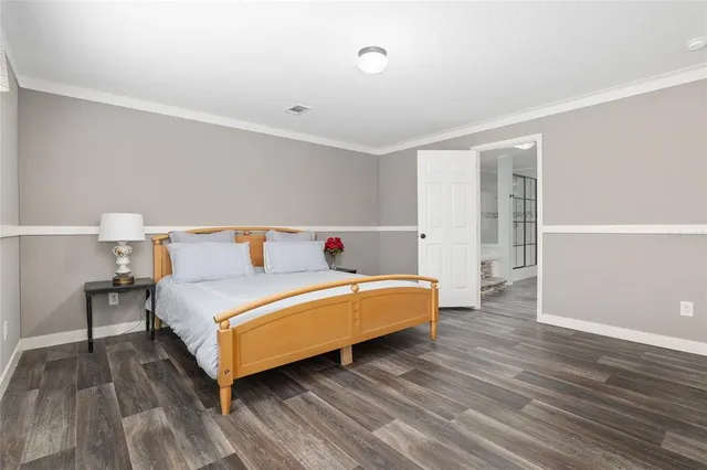 a bedroom with a bed and wooden floor