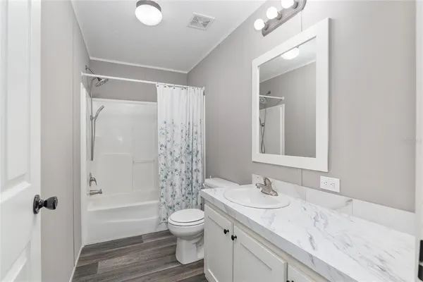 a bathroom with a granite countertop sink toilet a shower and a mirror