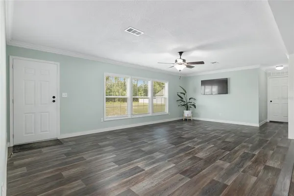 a view of a livingroom with a ceiling fan and window