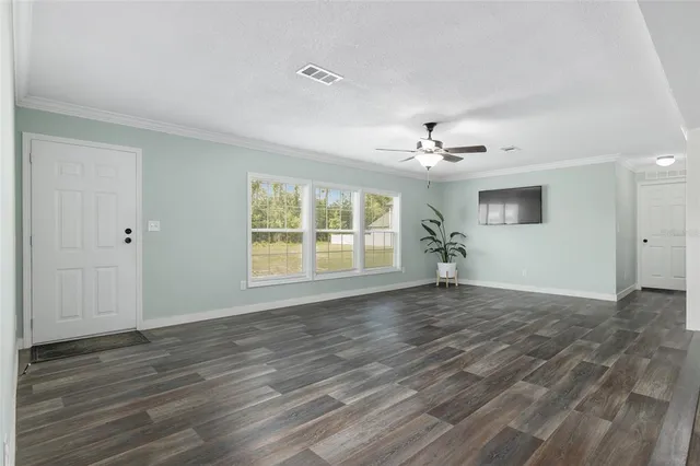 a view of a livingroom with a ceiling fan and window