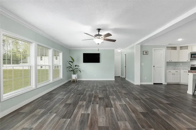 a view of a livingroom with a hardwood floor and a ceiling fan