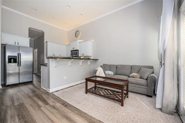 a living room with furniture a flat screen tv and a window