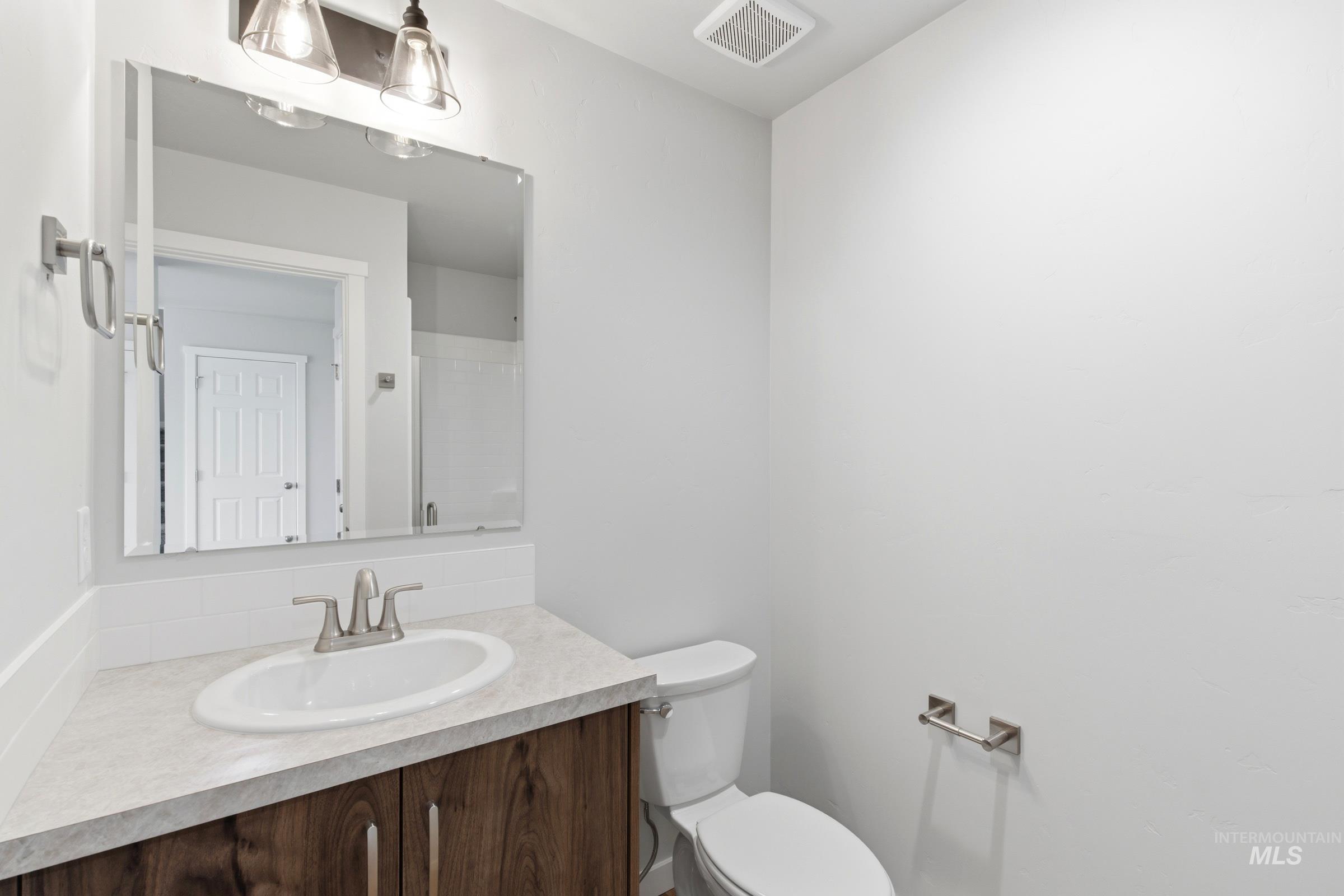 16558 Dunning Way Caldwell, ID 83607 - Photo 14 of 35 Bathroom with a wood-finish vanity, integrated sink, and brushed nickel faucet