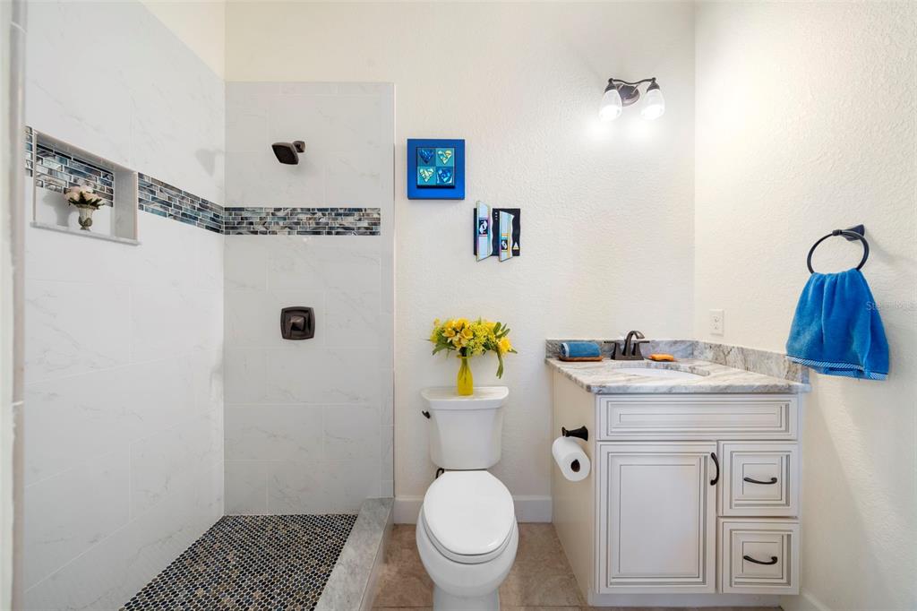 13023 Sweet Hill Road Polk City, FL 33868 - Photo 17 of 49 a bathroom with a granite countertop toilet sink and mirror