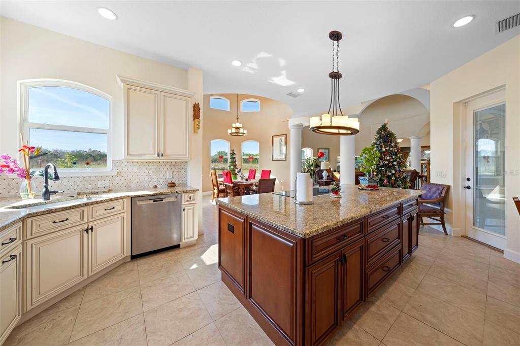 13023 Sweet Hill Road Polk City, FL 33868 - Photo 24 of 49 a kitchen with granite countertop counter space a sink stainless steel appliances and cabinets