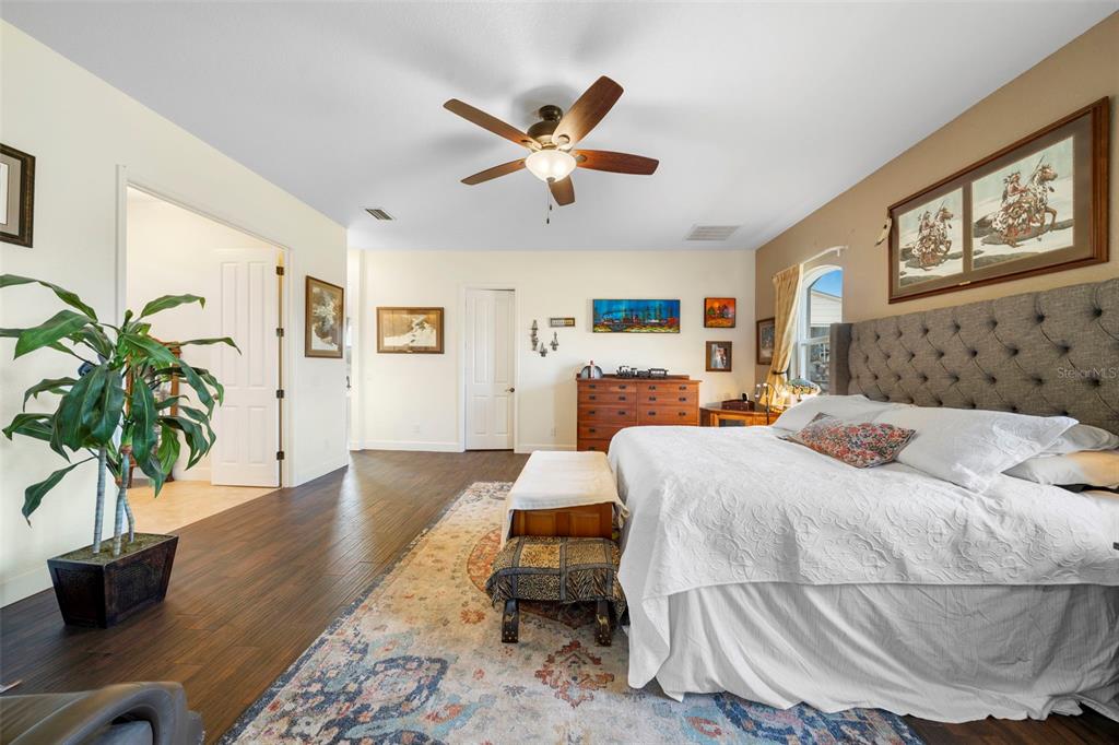 13023 Sweet Hill Road Polk City, FL 33868 - Photo 26 of 49 a bedroom with a large bed and a chandelier