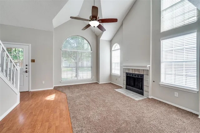 an empty room with windows and fireplace