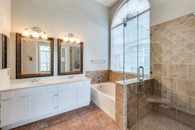 a spacious bathroom with a tub sink and mirror