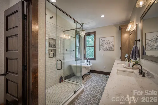 a bathroom with double vanity sinks a large mirror and a shower