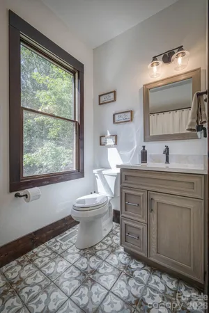 a bathroom with a toilet a sink and a window